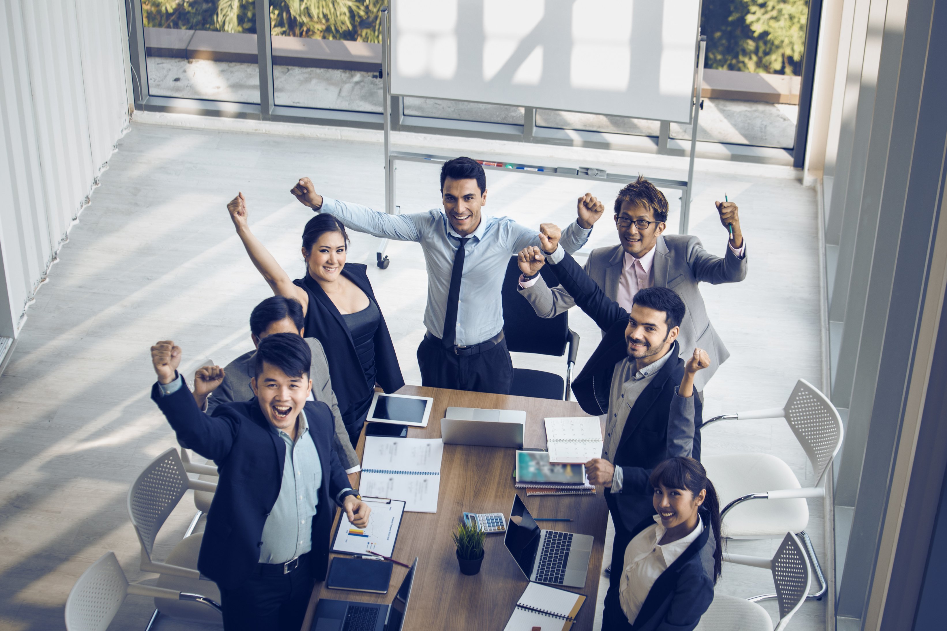 Team of Business People Raising Their Hands in Success 